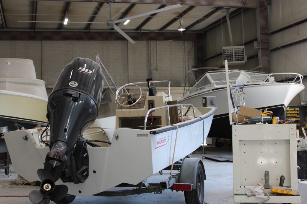 White Boston Whaler boat inside of Absolute Marine on trailer. Two other boats on trailers can be seen in the background.